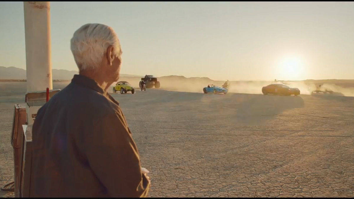 Eon-Spot: Der alte Tankwart blickt verbittert auf die vorbeirauschende E-Fahrzeugkolonne.